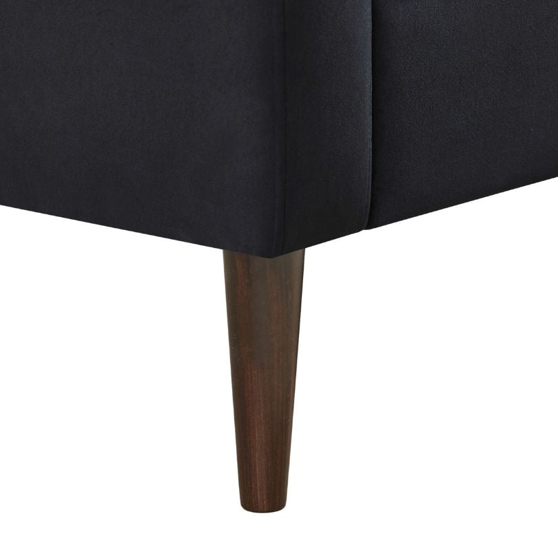 Side view of the stylish black barrel chair showcasing its tufted design.