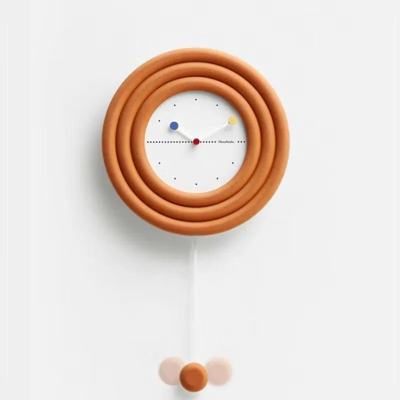 Close-up view of the bamboo material and metallic accents of the minimalist clock on a white wall.