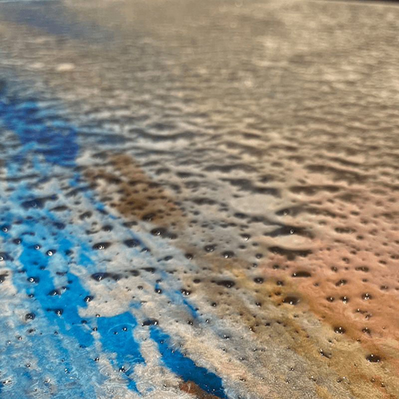 Close-up of the colorful surface of the ripple glass coffee table highlighting its artistic design.