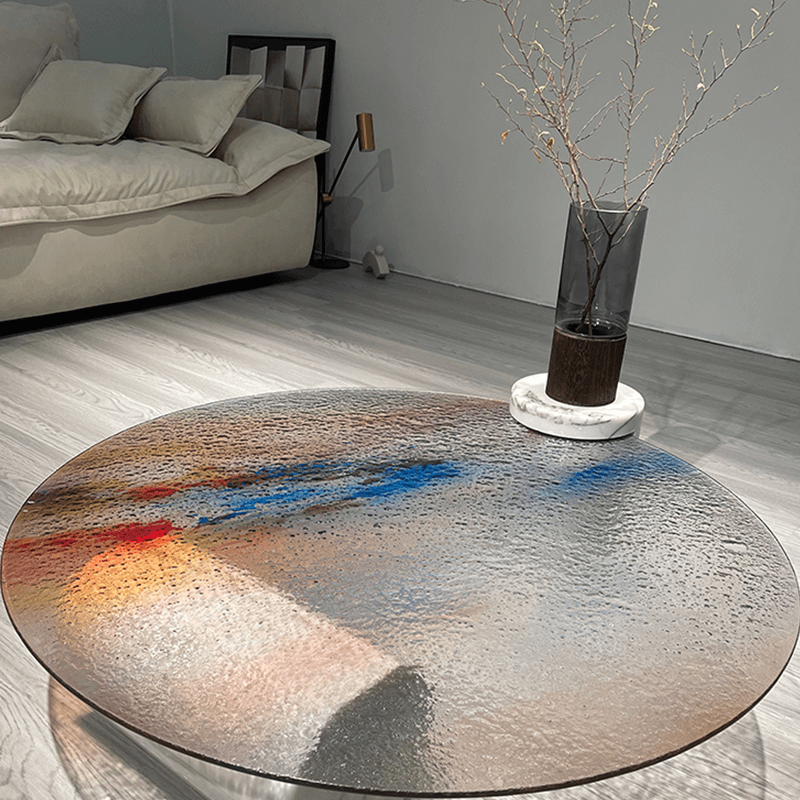 The ripple glass coffee table placed on a terrace, surrounded by lush plants and outdoor furniture.