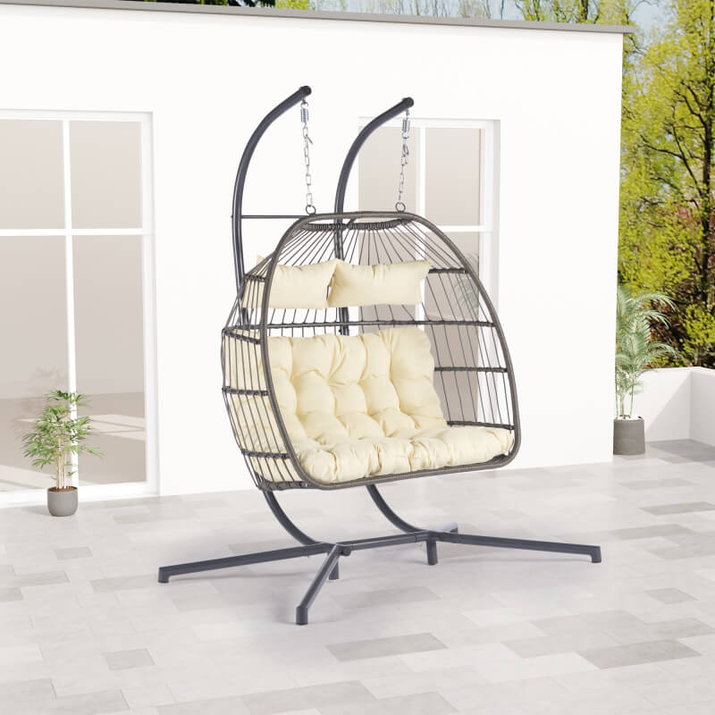 Side view of the stylish rattan egg chair for two on a patio.