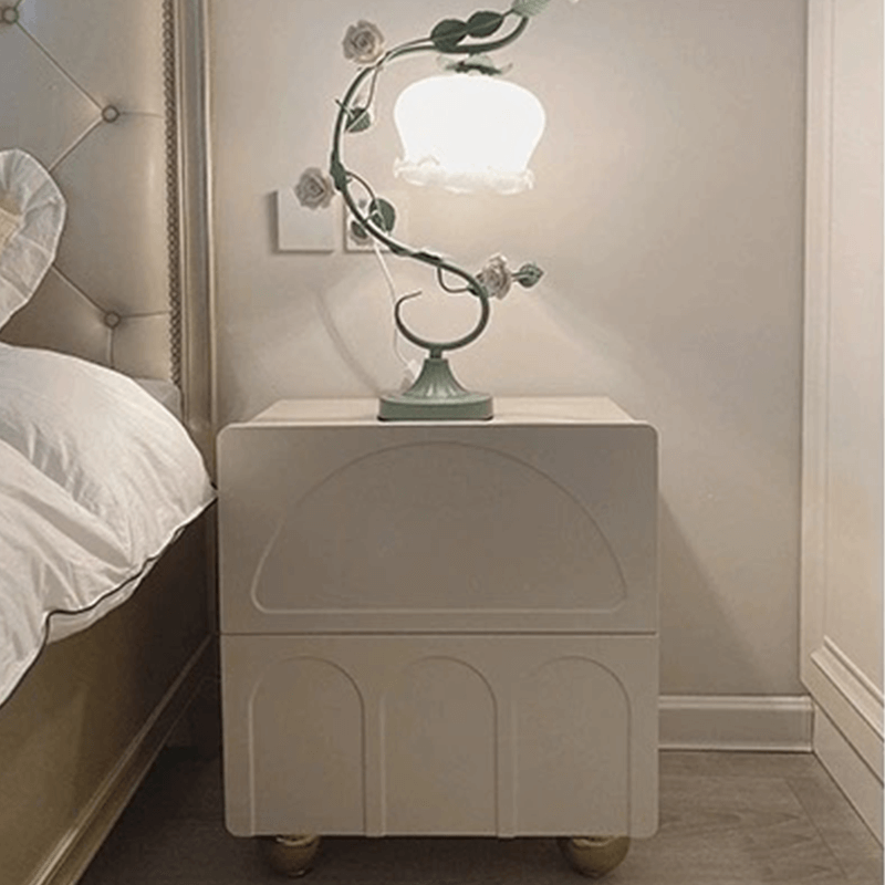 View of the white bedside table with metal hardware in a cozy bedroom setup.