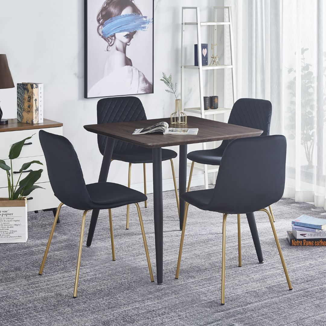 Close-up of the gold legs on a black dining chair, highlighting the sleek finish and craftsmanship.