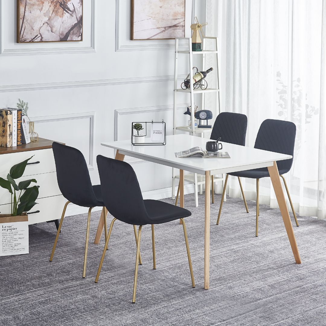 Elegant view of black velvet dining chair with gold legs, showcasing its modern design.