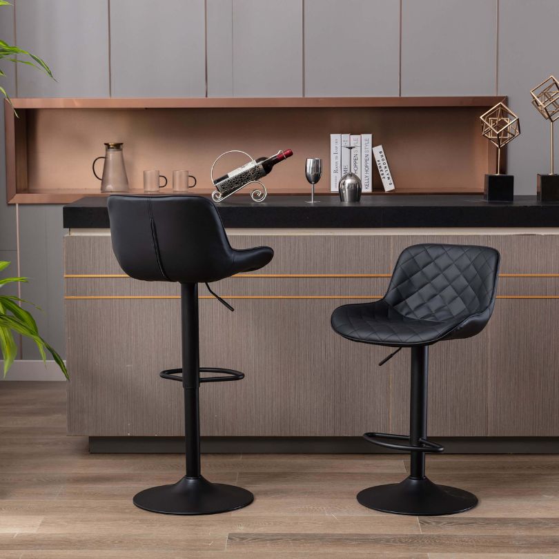 Side angle of black velvet bar stools displaying the adjustable height feature in a modern dining setting.