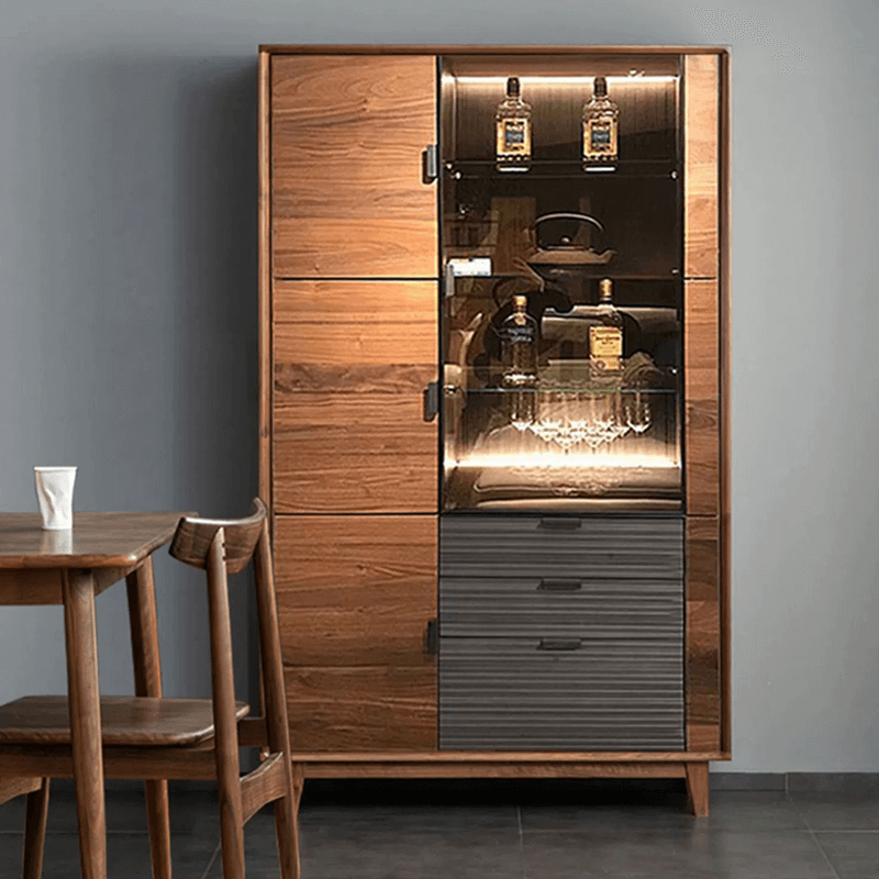 Elegant black walnut wine cabinet showcasing wine bottles and glasses from a side angle.