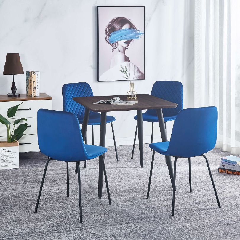 Side perspective of a blue velvet dining chair set in a stylish dining room, highlighting its elegant color.
