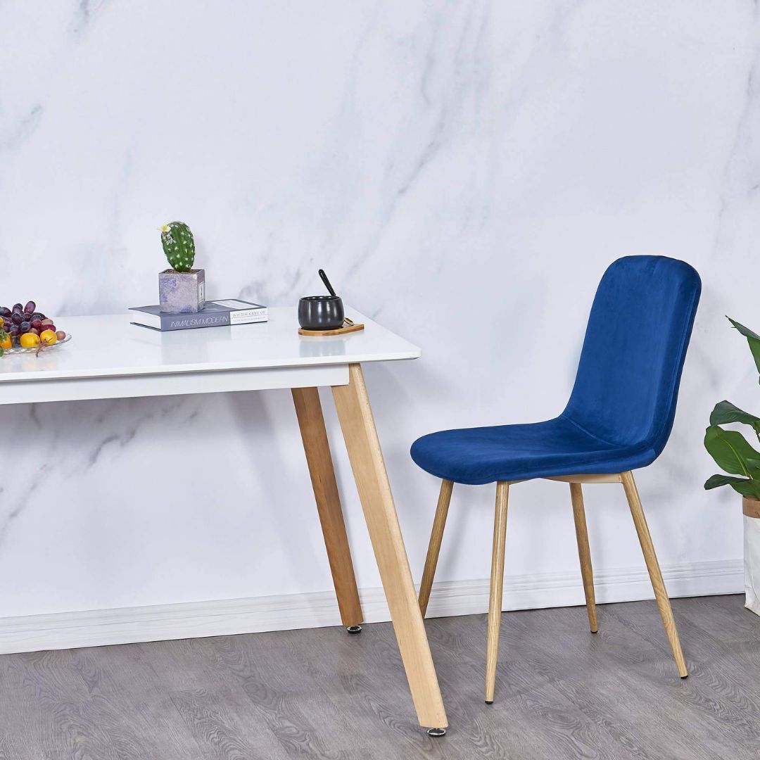 Blue velvet kitchen chair in a dining room setting, demonstrating its versatility and elegance.