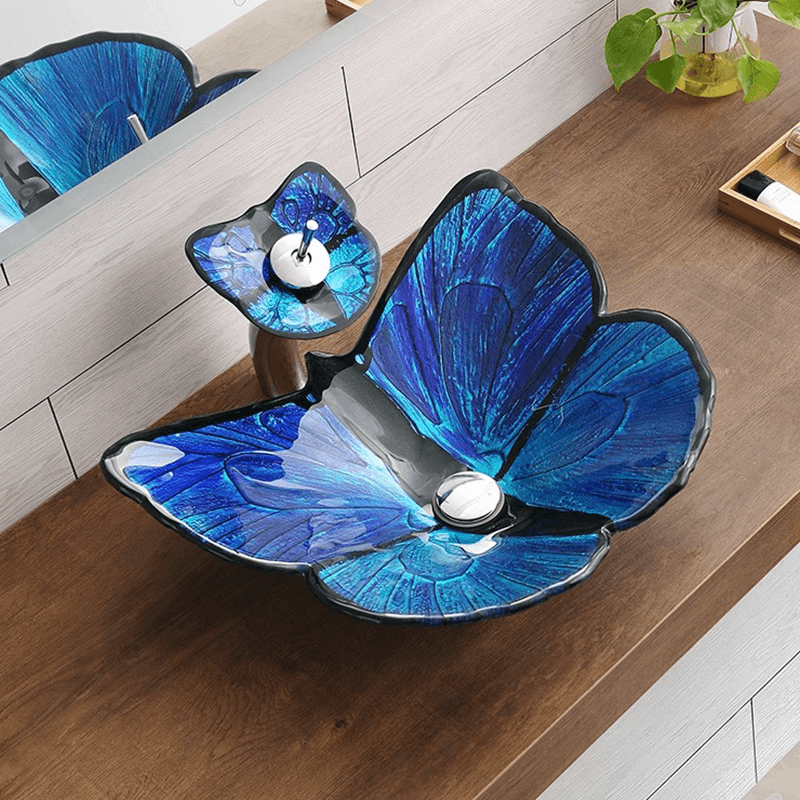 Close-up view of the elegant butterfly-shaped bathroom sink showcasing its tempered glass and waterfall faucet.