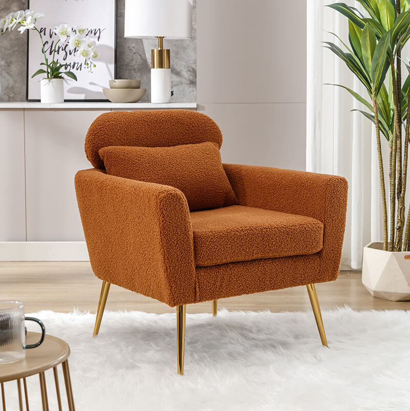 Caramel boucle accent chair with gold legs in a living room setting.