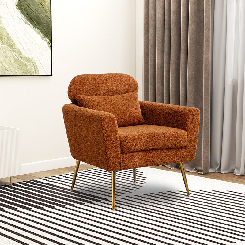 Caramel boucle accent chair with gold legs in a living room setting.