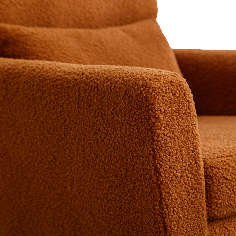 Caramel boucle accent chair with gold legs in a living room setting.