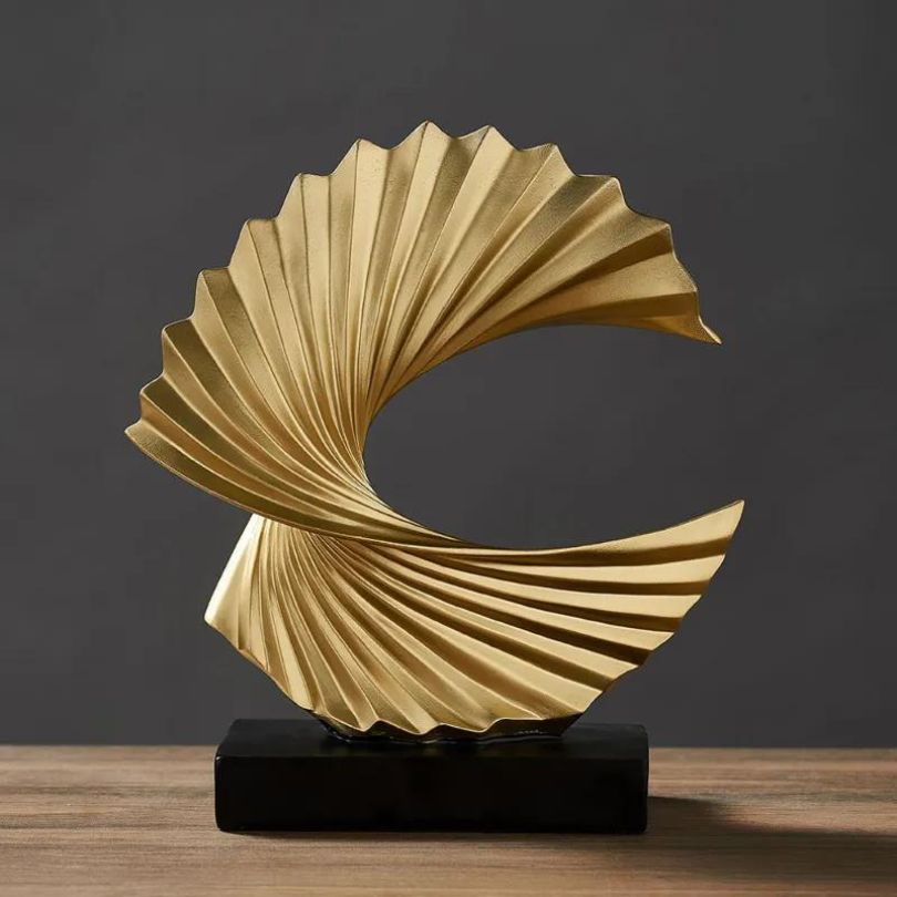 Front view of the modern golden abstract statue highlighting its unique shape.