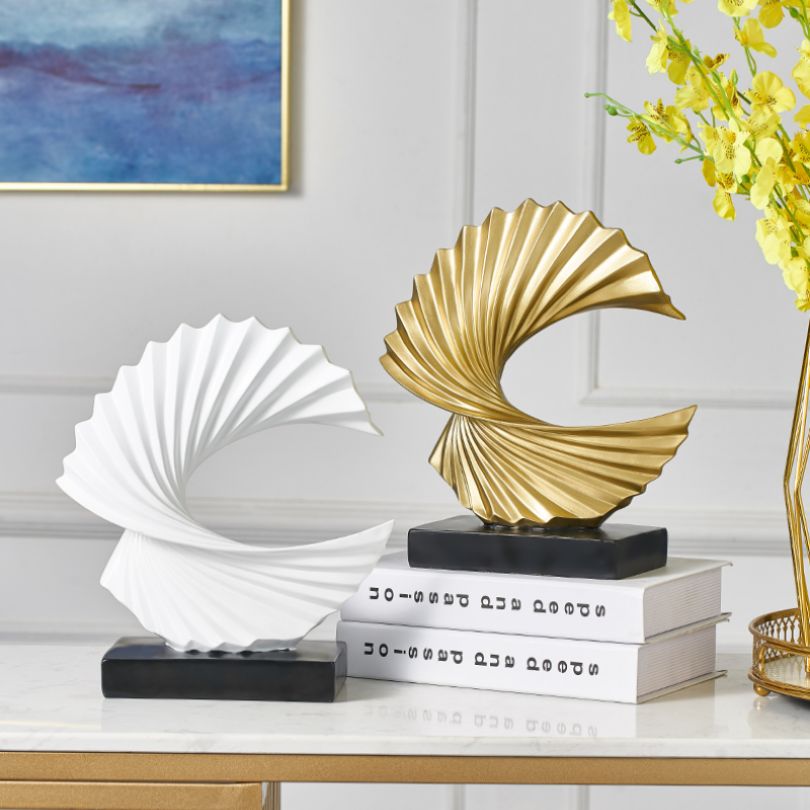 Front view of the modern golden abstract statue highlighting its unique shape.