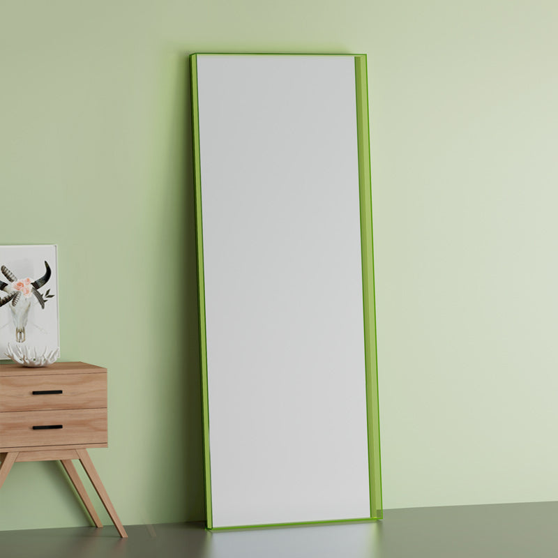 Orange Vetra Luxe full length mirror leaning against a white wall in a minimalist bedroom