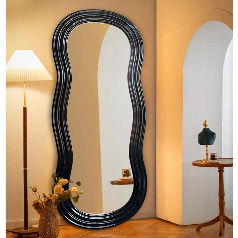Stylish irregular full length mirror displayed in a modern living room setting.