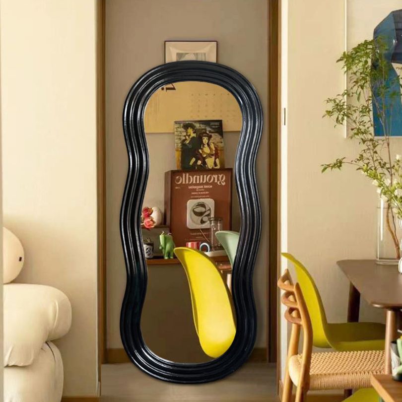 Stylish irregular full length mirror displayed in a modern living room setting.