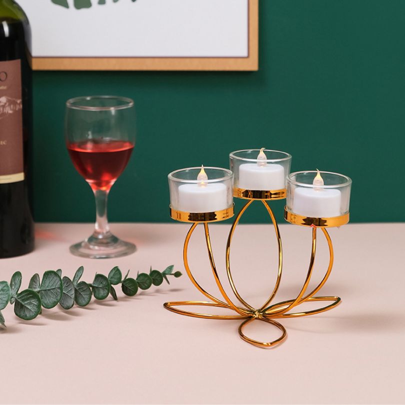 Elegant gold candle holder showcasing the warm glow of a stick candle on a dining table.
