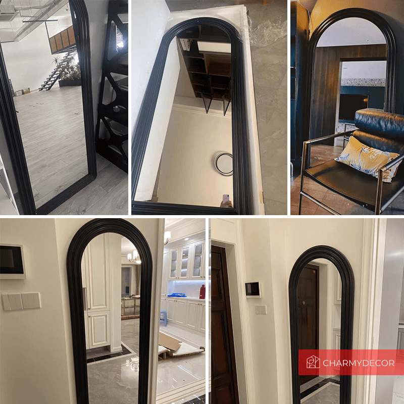 Black wall mirror with arched frame reflecting a chic bedroom atmosphere.