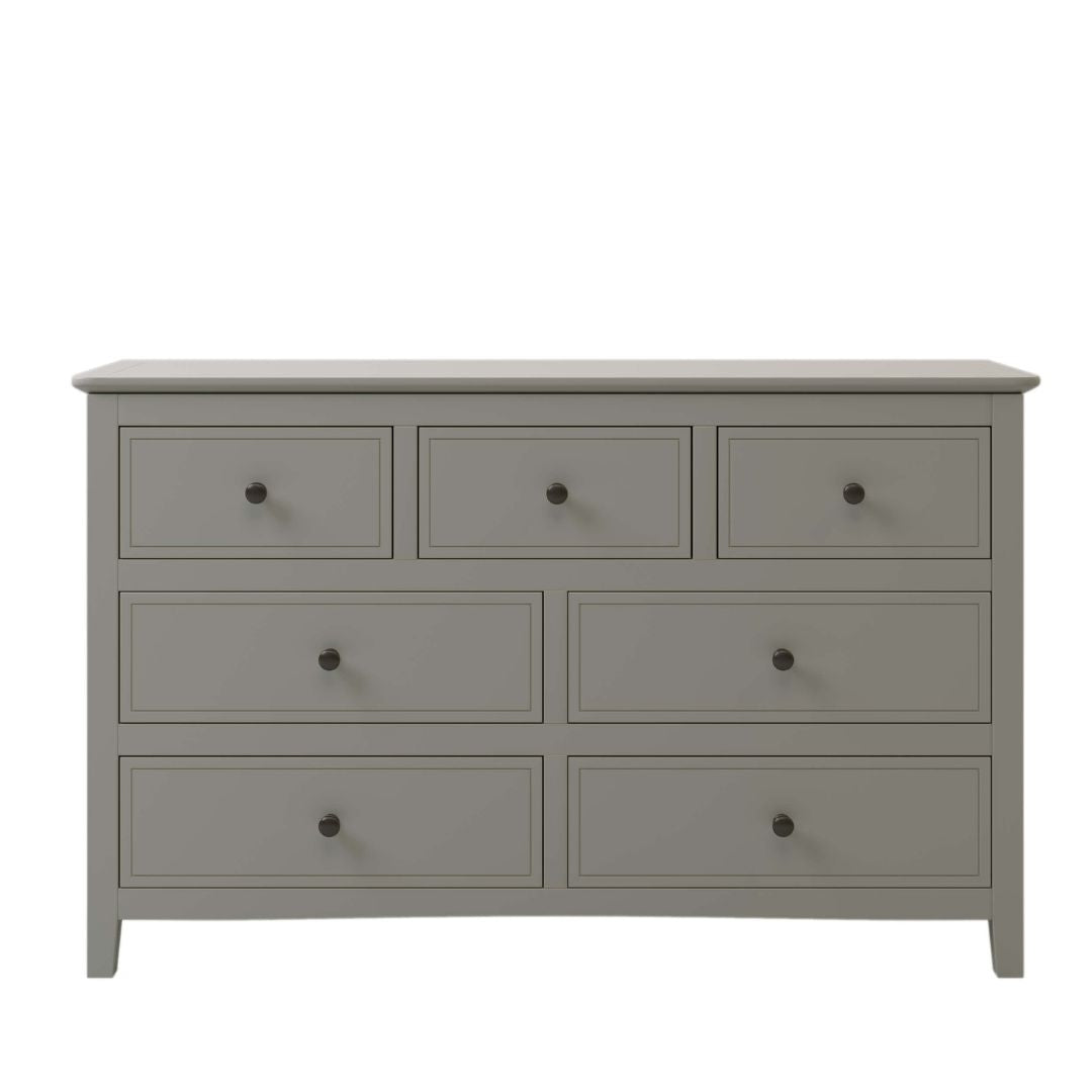 Angled view of the stylish gray dresser in a cozy bedroom setting.
