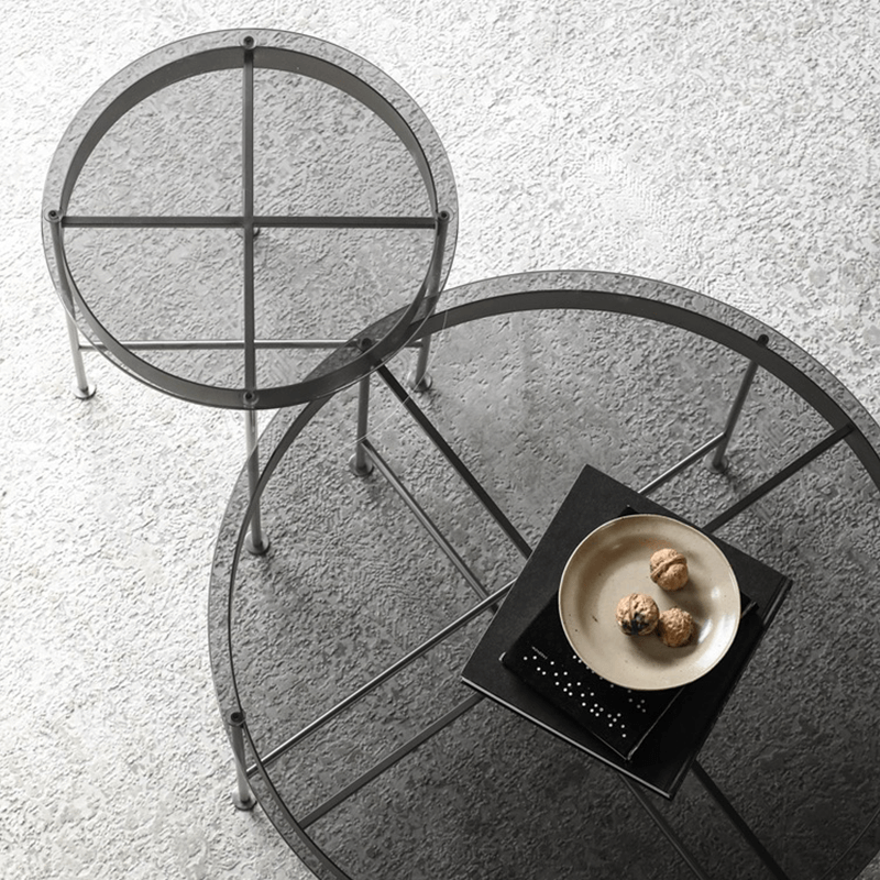 Close-up of the durable steel frame supporting the round glass top of the coffee table.