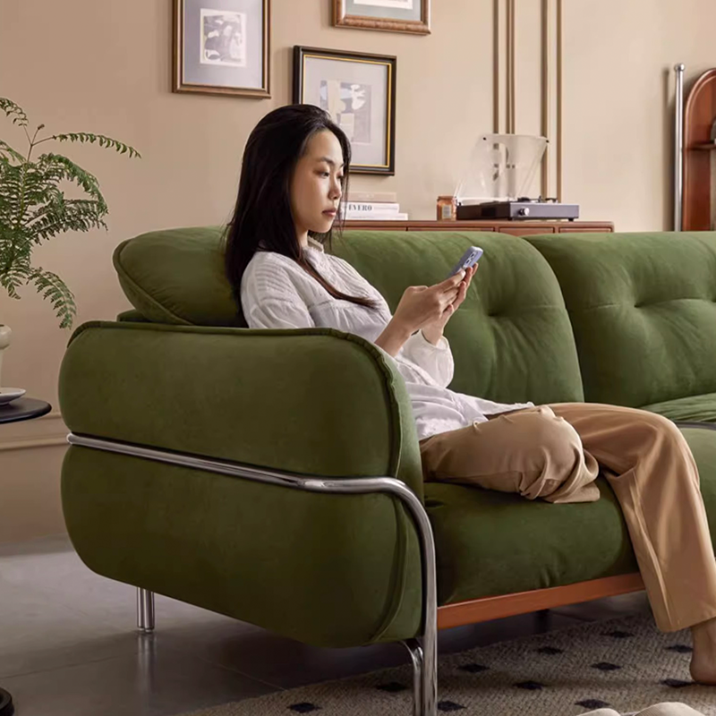 Chic modern upholstered tufted pouf sofa in green against a stylish backdrop.