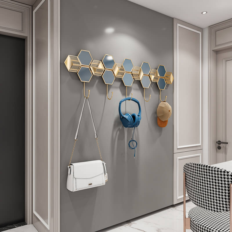 Side view of sleek floating modern coat hooks displaying coats and bags in a stylish entryway.