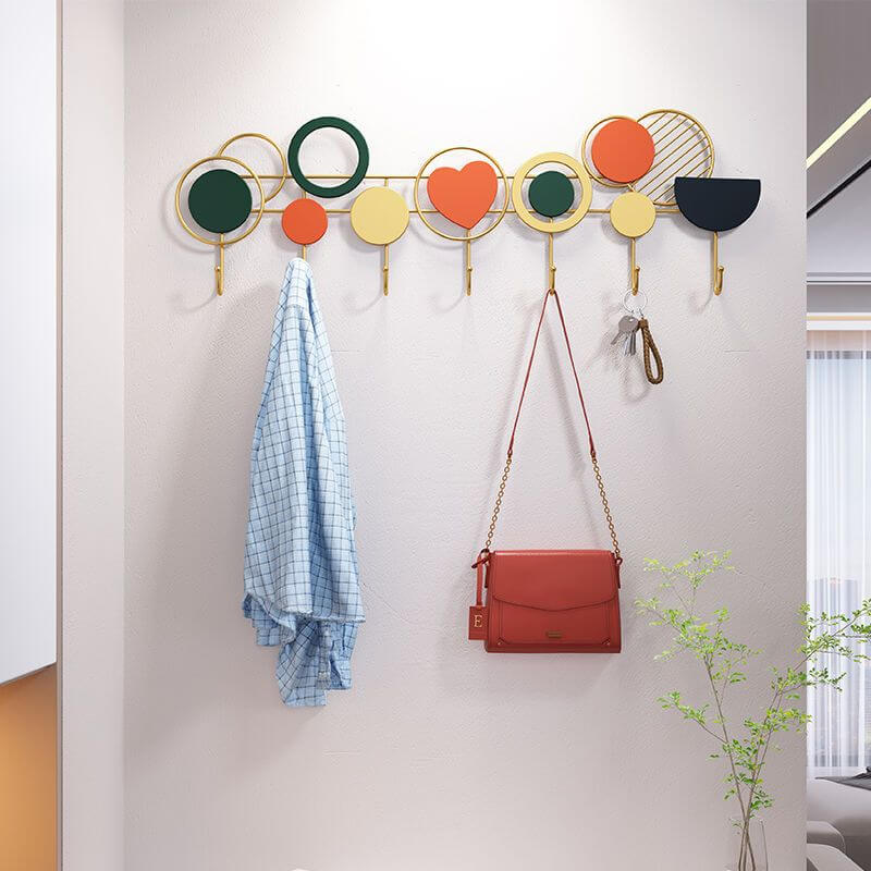 Artistic modern metal wall coat rack showcasing colorful hooks in a stylish entryway.