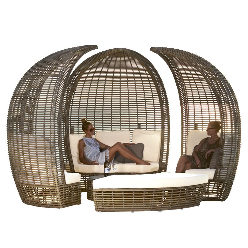 Elegant round rattan poolside daybed in a sunny garden setting, showcasing its sleek design and canopy.