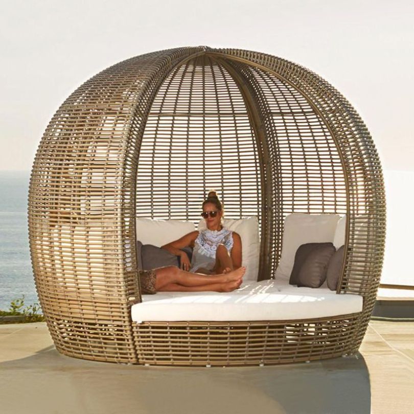 Close-up of the luxurious cushions on the round rattan daybed, perfect for lounging in comfort.