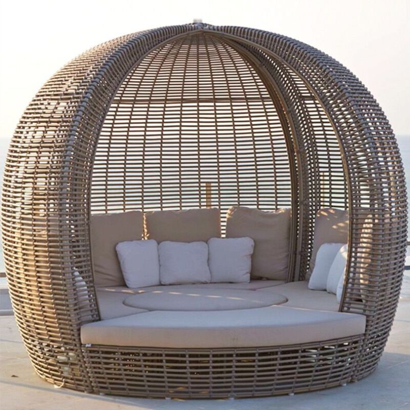 Close-up of the luxurious cushions on the round rattan daybed, perfect for lounging in comfort.