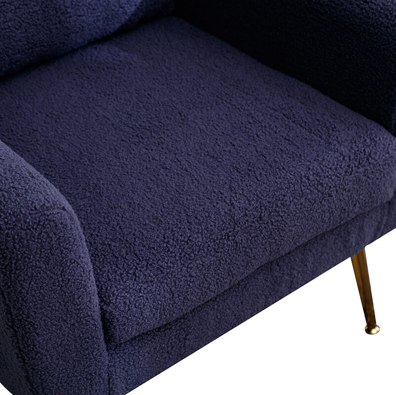 Close-up of the navy boucle accent chair with the throw pillow highlighting its comfort