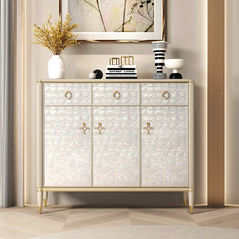 Elegant off-white shoe storage cabinet with doors, showing a side view in a bright entryway.