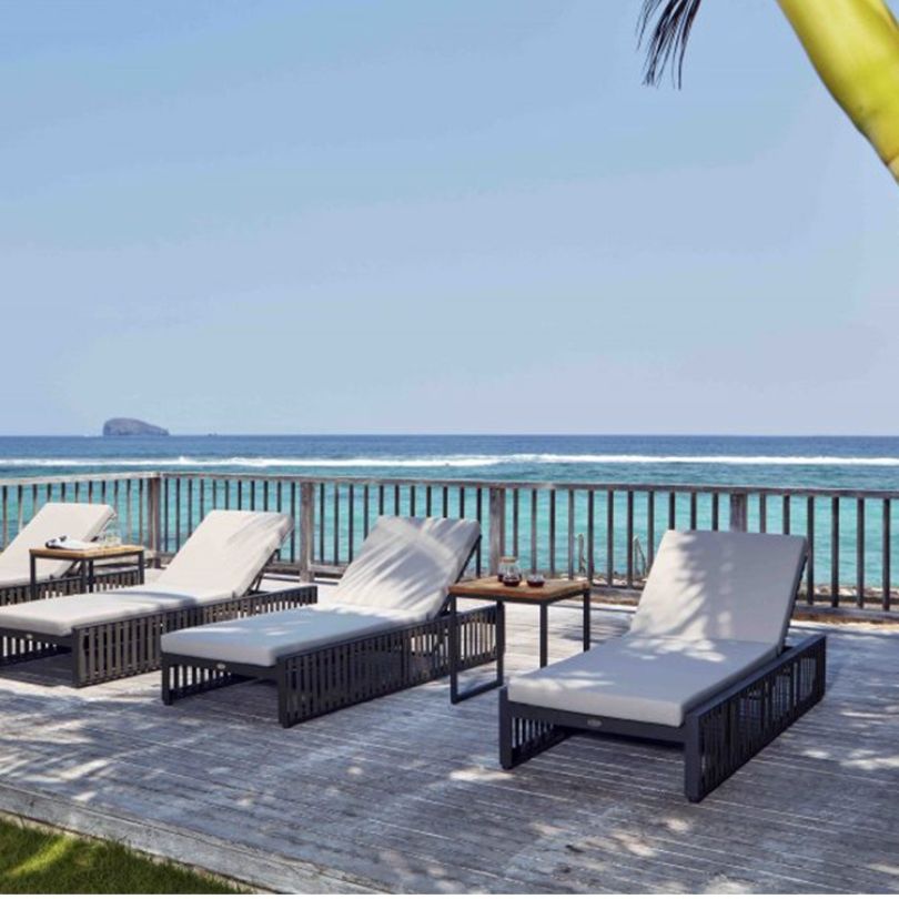 Lounge chair and sofa from the outdoor metal furniture set with armrests on a sunny patio