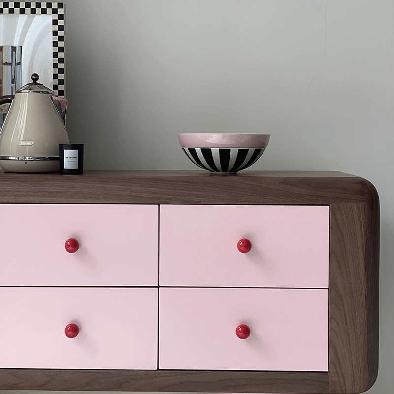 Side angle of the pink wooden dresser showing elegant ceramic accents