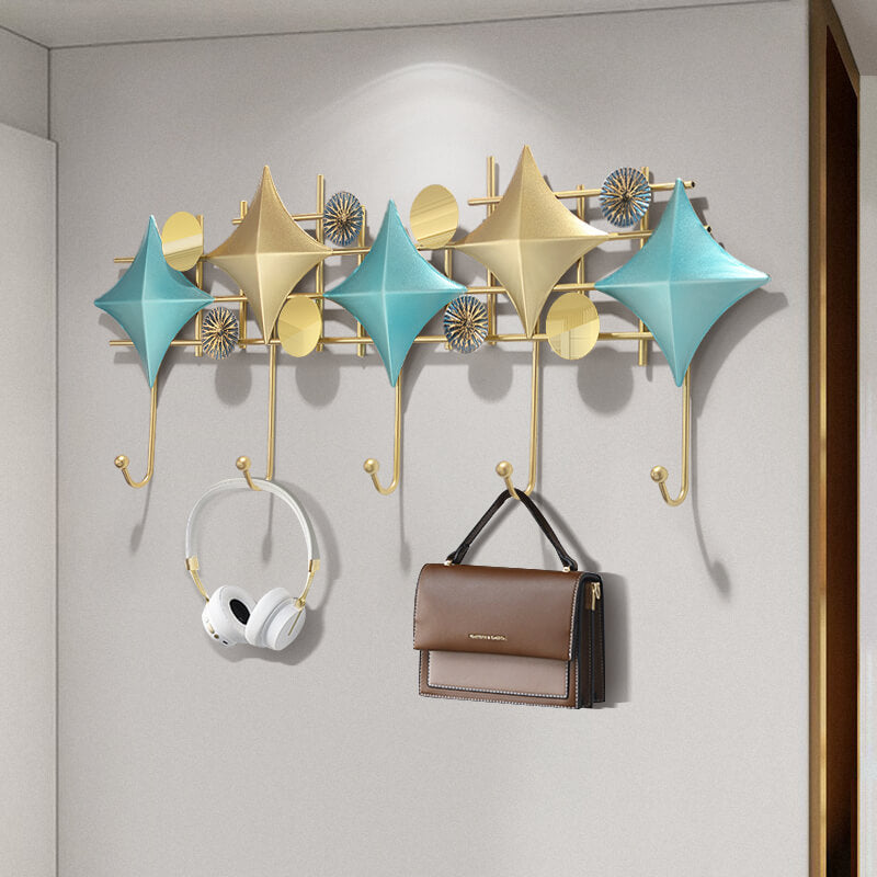 Sculptural modern coat rack with gold and blue finish, showcasing hooks for entryway organization.
