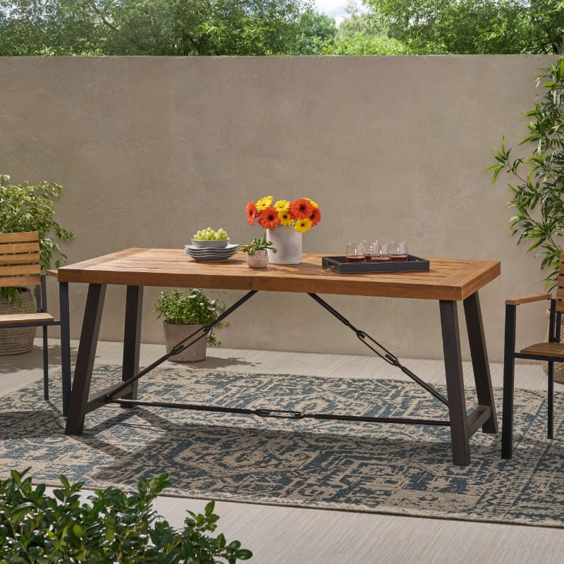 Rustic Charm Industrial Outdoor Dining Table set up on a sunny patio, showcasing its spacious surface for dining.