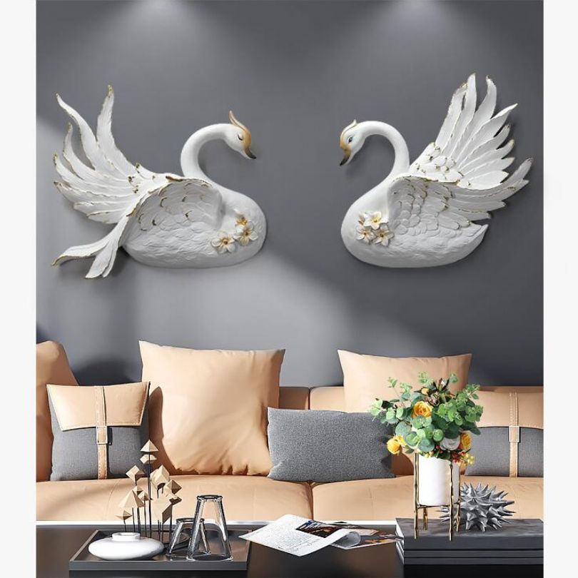 Elegant swan figurine wall decoration hanging above a couch.