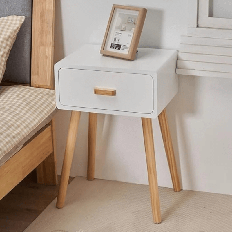 Elegant modern white nightstand set showcasing sleek design and wooden legs from a side angle.