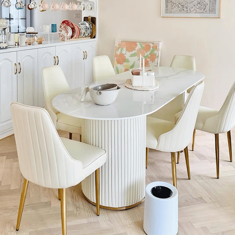 Dining area featuring the modern oval marble dining table with stylish decor.
