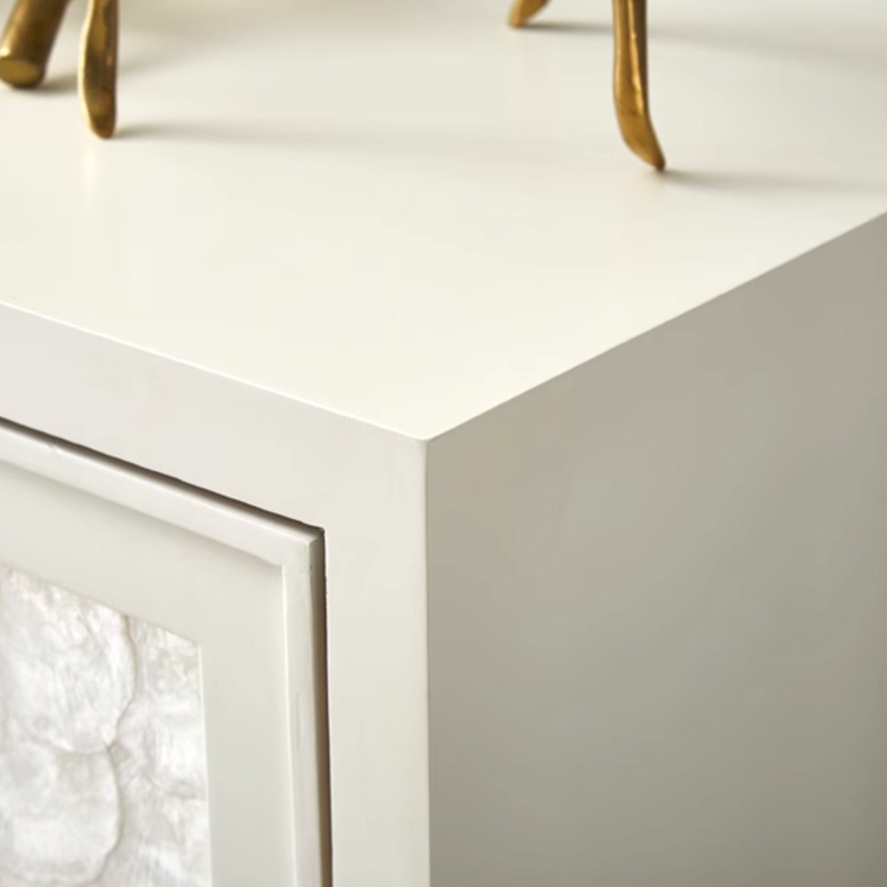 Close-up of modern furniture details, including white finish and stainless steel accents