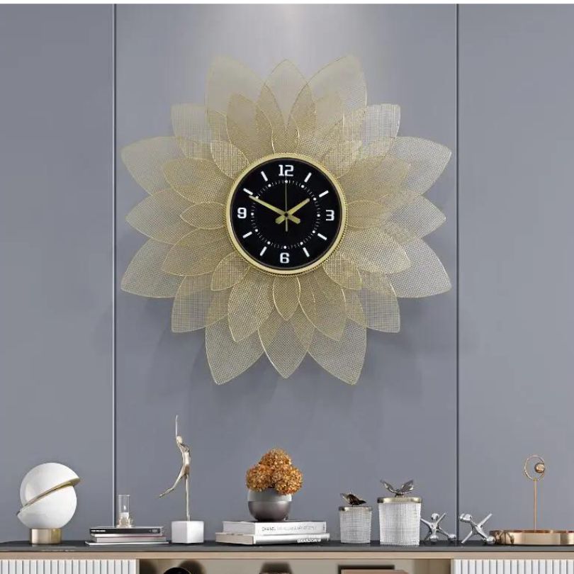 Sophisticated view of the gold wrought iron wall clock on a white wall.