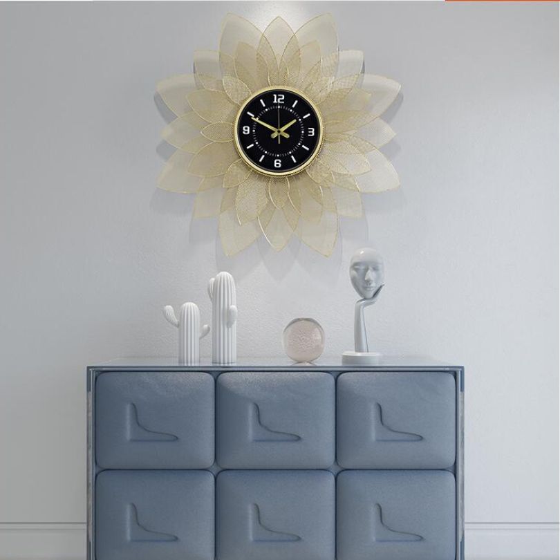 Sophisticated view of the gold wrought iron wall clock on a white wall.