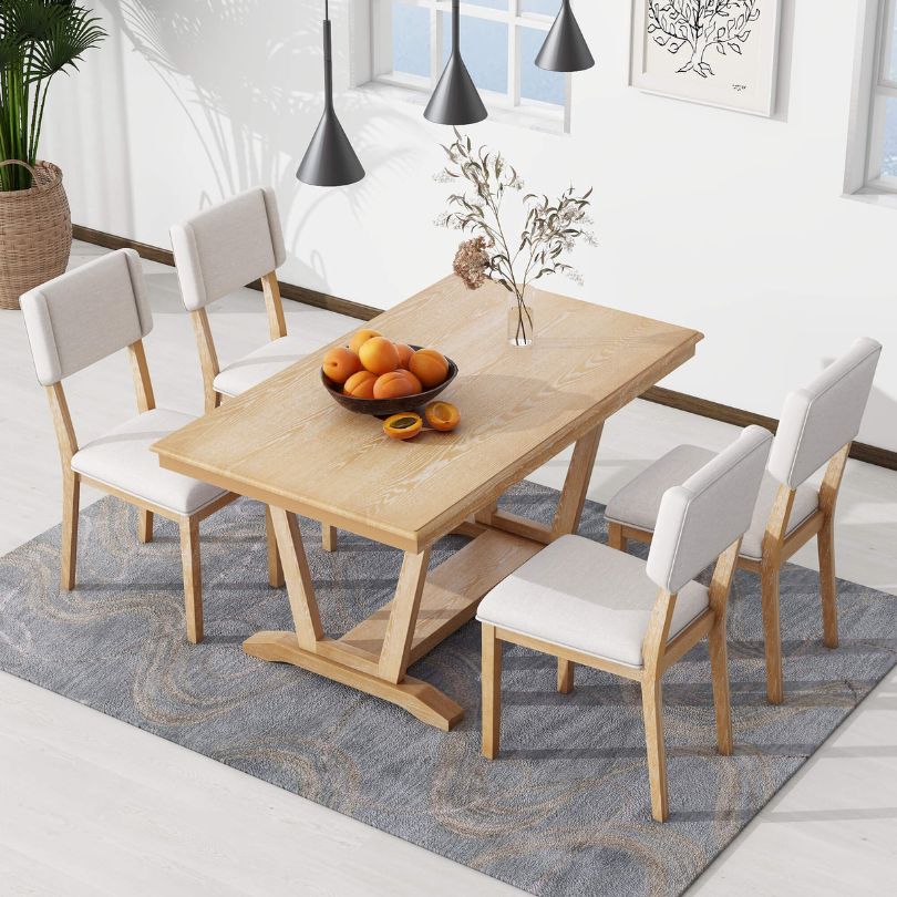 Close-up of the rectangular dining table with trestle base showcasing its natural finish.