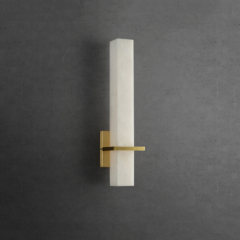 Close-up of the square marble shade and golden base of the wall lamp.