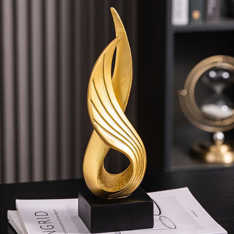 Close-up view of the gold resin abstract wing ornament, highlighting its craftsmanship.