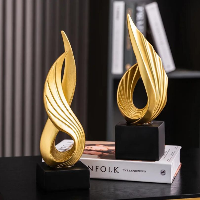 Close-up view of the gold resin abstract wing ornament, highlighting its craftsmanship.