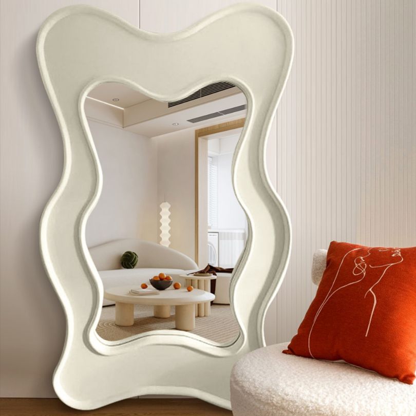 View of the Nordic Wave Asymmetrical Floor Mirror reflecting natural light in a cozy corner