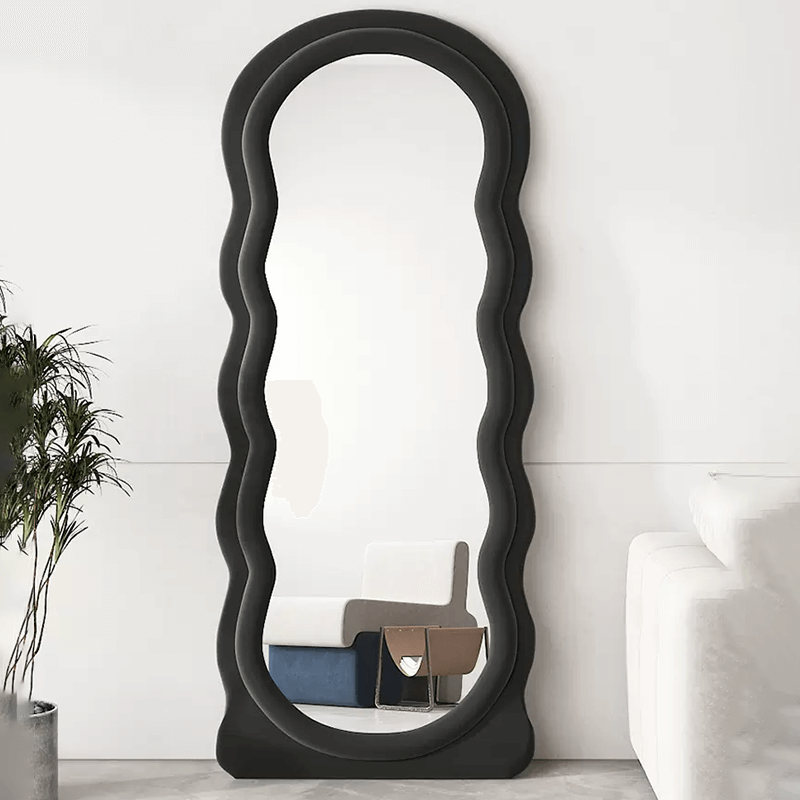 Curvy black full length mirror showcasing its unique wave shape in a stylish bedroom setting.