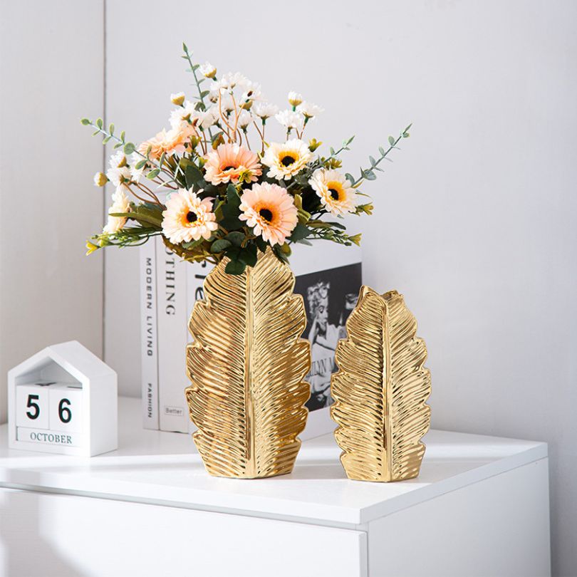 Nordic gold pleated leaf ceramic vase set on a mantel, enhancing the rooms decor with elegance.